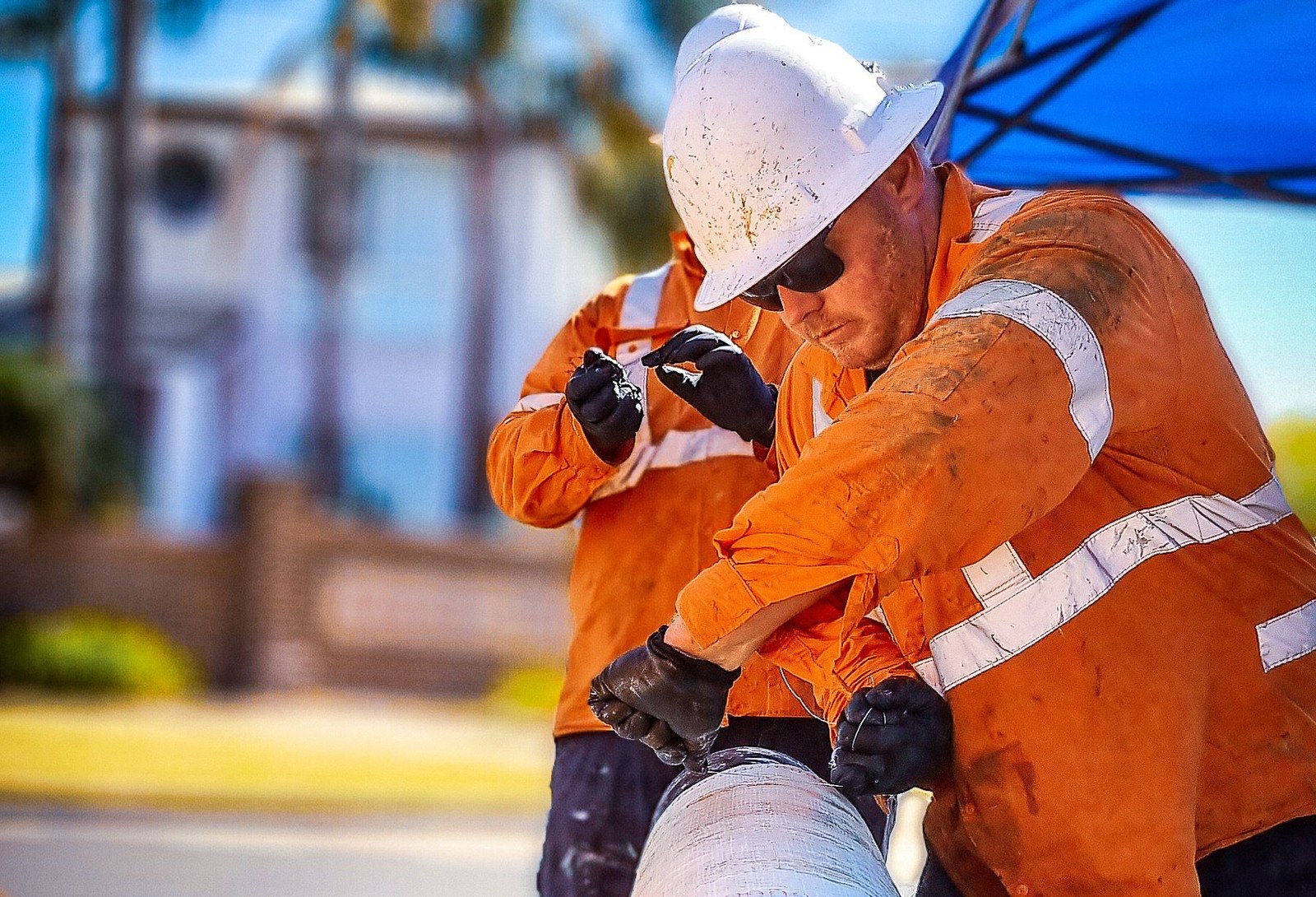 Plumbing worker in hi-vis gear on an urgent outdoor job