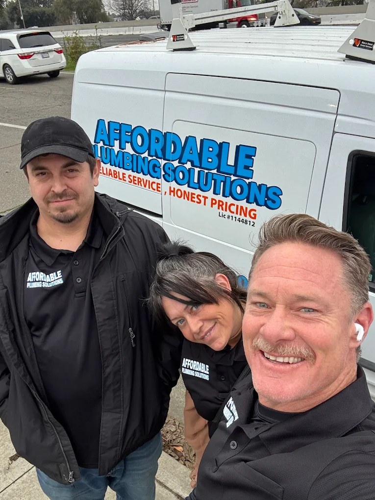 The Affordable Plumbing Solutions team standing in front of their work van